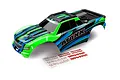Traxxas Maxx 4S green painted RC truck body shell with blue and black graphics and an included decal sheet on a white background.