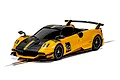 A yellow and black Scalextric 1/32 scale Pagani Huayra BC Roadster slot car on a track.