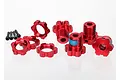 Traxxas red anodized aluminium 17mm splined wheel hex adapters and matching wheel nuts with small black screws on a white background.