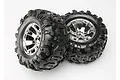 Two Traxxas 3.8 inch Canyon AT monster truck tires pre-glued onto shiny chrome Geode wheels against a plain white background.