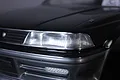 Close-up of a black RC car body showing a detailed 3D headlight decal applied to the front corner.