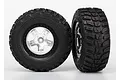 Two Traxxas 2.2/3.0 inch Kumho Road Venture MT tires pre-glued to satin chrome and black wheels against a white background.