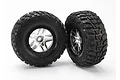 Two Traxxas 2.2/3.0 inch Kumho Road Venture MT tires mounted on satin chrome split-spoke wheels against a white background.