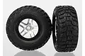 Two Traxxas 2.2/3.0 inch Kumho Road Venture MT tires pre-glued onto satin chrome split-spoke wheels against a white background.