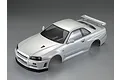 A pearl white painted 1/10 scale RC body shell of a Nissan Skyline R34, shown from a high-angle studio view.