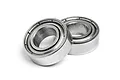 Two metallic ball bearings shown at an angle against a white background.