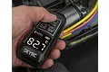 A hand holding a black SkyRC infrared thermometer gun, pointing it at an RC car motor to measure its temperature, showing 82.7 degrees Celsius on the screen.