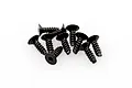 A small pile of black countersunk head screws with coarse threads and hex drive sockets.