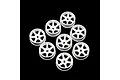 A set of seven white plastic six-spoke RC car rims arranged on a black background.