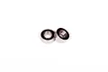 Two small metal ball bearings with black rubber seals sitting on a white background.