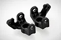 Two black plastic RC steering hub carriers for HSP remote control vehicles, shown from a high angle on a white background.