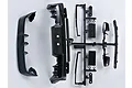 Black plastic injection molded RC car accessory parts for a Mitsubishi Lancer Evolution X, including a spoiler, bumper, and side mirrors on a sprue.