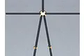 A black RC scale model safety harness with gold-coloured metal buckles laid out on a grey surface.