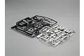 Two plastic parts trees for a 1/10 scale RC car, one black and one chrome-plated, laid out on a grey studio background.