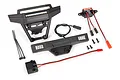 Traxxas Hoss 4x4 LED light kit including front bumper with light bar, rear light housing, power supply module, wiring, and mounting hardware.