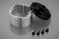 A silver aluminium differential housing with a black end cap and four small black screws on a grey reflective surface.