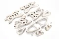 A set of white plastic RC suspension arms and mounting components arranged on a white background.