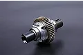 A complete silver aluminium RC differential assembly with a large brass-coloured gear, isolated against a dark grey background.