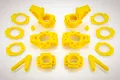A set of bright yellow Rovan RC car suspension parts including hub carriers, rings, and arms arranged on a white background.