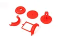 A set of red plastic RC air filter mount components arranged on a white background.