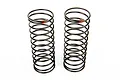 Two black RC shock springs standing upright on a white background, each featuring a small red paint mark at the top coil.