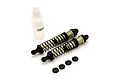 Two Kyosho aluminium RC shock absorbers with black springs, a small bottle of shock oil, and four small black plastic spacers on a white background.