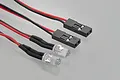 Two clear LED lights connected to red and black wires with black plastic servo-style connectors on a light grey background.