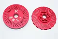 Two red anodized aluminium RC wheel hex adapters with a perforated disc design, showing front and back views.
