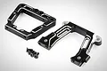 Two black anodized aluminium RC rear bulkhead components with silver machined edges and four small black screws on a white background.