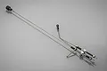 Rovan Baja 71cc throttle and brake linkage set featuring metal rods, springs, and plastic connectors on a grey reflective surface.