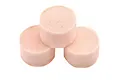 Three cylindrical pink foam air filter inserts arranged in a triangular formation against a white background.