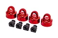 Four red anodized aluminium shock caps and four black plastic spacers for Traxxas RC vehicles.