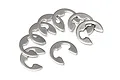 A collection of eight silver-coloured metal E-clips arranged on a white background.