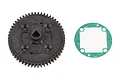 A black plastic spur gear and a green and white paper gasket for an RC car, isolated on a white background.