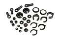 A collection of black plastic RC shock absorber spare parts including ball ends, spring retainers, spacers, and clips on a white background.