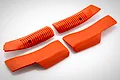 A set of four bright orange rubberized grip covers for a Spektrum iX14 RC transmitter, featuring textured surfaces and molded logos.