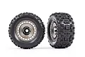 Two Traxxas Sledgehammer 3.8 inch RC monster truck tires mounted on satin black chrome modular wheels against a white background.