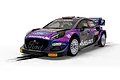 A 1/32 scale Scalextric Ford Puma WRC slot car in purple livery with sponsor decals, positioned on a slot car track section.