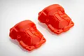 Two bright orange plastic RC gearbox case halves shown from a top-down perspective on a white background.