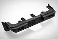A black plastic rear bumper spare part for an RGT RC vehicle, featuring mounting brackets and light bucket cutouts.