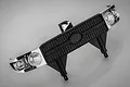 A black and chrome RGT front grille accessory for an RC vehicle, featuring a textured honeycomb pattern and integrated light bucket housings.