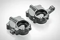 Two black anodized aluminium steering hub carriers for RGT RC cars, shown from a high angle on a white background.