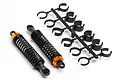 Two assembled RC shock absorbers with black springs and orange caps, alongside a plastic tree of black suspension spacers.