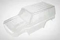 A clear, unpainted 1/10 scale RC crawler body shell for the RGT Rescuer, viewed from a high angle against a plain white background.