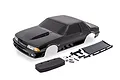 A black Traxxas Ford Mustang Fox body shell for a 1/10 scale Drag Slash RC car, including a rear wing, foam bumper, side mirrors, and mounting hardware.