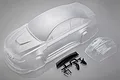 An unpainted clear polycarbonate RC car body shell for an E92 model, including a separate front bumper piece and black plastic accessories on a sprue.