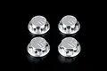 Four silver aluminium RC tyre nuts with a logo engraved on the top, arranged in a 2x2 grid against a black background.