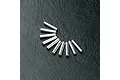 Ten small silver metal axle pins arranged in a semi-circle on a black textured surface.