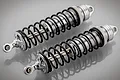 Two Rovan silver aluminium adjustable RC car shock absorbers with black springs on a grey reflective surface.
