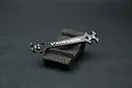 A black Koswork multi-size turnbuckle wrench resting on a piece of black foam against a dark background.